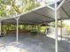 Carport with stacked lumber, seating, and covered parking, providing ample outdoor storage at 9148 Oakwood Dr, Lake Wales, FL 33898