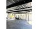 View of the covered carport with a storage room, housing an ATV and various tools at 9148 Oakwood Dr, Lake Wales, FL 33898
