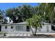 Charming single-story home with lush tropical landscaping and a beautifully paved driveway at 9148 Oakwood Dr, Lake Wales, FL 33898