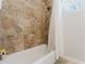 Modern tiled bathroom with a shower, tub, and natural light at 9285 Wickham Way, Orlando, FL 32836
