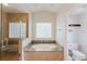 Bathroom featuring a soaking tub, glass shower, and a toilet in a separate alcove at 9285 Wickham Way, Orlando, FL 32836