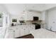 Open kitchen boasts white cabinets, granite counters, and modern appliances at 9285 Wickham Way, Orlando, FL 32836