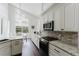 Bright kitchen featuring granite countertops, stainless steel appliances, and custom cabinets at 9285 Wickham Way, Orlando, FL 32836