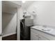 Efficient laundry room featuring modern washer/dryer, sink, and shelving at 9285 Wickham Way, Orlando, FL 32836