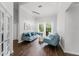 Bright living room with hardwood floors, elegant furniture, and a view of the pool through large windows at 9285 Wickham Way, Orlando, FL 32836