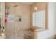 Walk-in shower featuring stone tile walls, glass enclosure, and natural light from block window at 9285 Wickham Way, Orlando, FL 32836