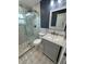 This newly remodeled bathroom features marble floors and countertops, a frameless shower and new stylish fixtures at 2315 Pembrook Dr, Orlando, FL 32810