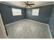 This spacious bedroom features stylish gray marble floors, a ceiling fan, and two windows to let natural light in at 2315 Pembrook Dr, Orlando, FL 32810