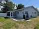 The rear of this single story house has an enclosed porch with a concrete patio at 2315 Pembrook Dr, Orlando, FL 32810