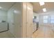 Hallway view with laundry closet and storage, leading to a bright kitchen with modern appliances at 1005 Black Willow Dr, Oviedo, FL 32765