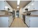 A well lit kitchen featuring white cabinets, stainless steel appliances, and a tile floor at 1005 Black Willow Dr, Oviedo, FL 32765
