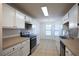 Well-lit kitchen featuring white cabinets, stainless steel appliances, and tile flooring at 1005 Black Willow Dr, Oviedo, FL 32765