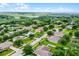 Aerial view of a property in a well-maintained neighborhood, surrounded by mature trees and landscaping at 1112 Spruce Ridge Ct, Minneola, FL 34715