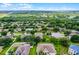 Aerial view of a property in a well-maintained neighborhood, surrounded by mature trees and landscaping at 1112 Spruce Ridge Ct, Minneola, FL 34715