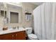 Cozy bathroom featuring a white shower curtain, a decorative shelf and a single sink vanity at 1112 Spruce Ridge Ct, Minneola, FL 34715