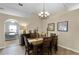 Dining room with chandelier, wood floors, and view into adjoining rooms at 1112 Spruce Ridge Ct, Minneola, FL 34715
