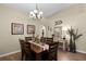 Formal dining room with chandelier, wooden table with seating, and wall decorations at 1112 Spruce Ridge Ct, Minneola, FL 34715
