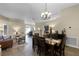 Open-concept dining room with a chandelier, wooden table, and a view into the living area at 1112 Spruce Ridge Ct, Minneola, FL 34715