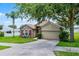 Charming one-story home with stone accents, manicured lawn, mature trees, and two-car garage at 1112 Spruce Ridge Ct, Minneola, FL 34715