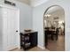 An arched entryway leads to the dining room with a cart in the hallway at 1112 Spruce Ridge Ct, Minneola, FL 34715
