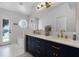 Main bath has double sinks, navy cabinets with gold hardware, and a standing tub at 1112 Spruce Ridge Ct, Minneola, FL 34715