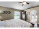 Main bedroom includes a ceiling fan, wood floors, a TV, and access to the bathroom at 1112 Spruce Ridge Ct, Minneola, FL 34715