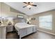 The main bedroom offers a ceiling fan, natural lighting, wood floors, and neutral decor at 1112 Spruce Ridge Ct, Minneola, FL 34715