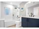 Well-lit bathroom featuring a shower, blue vanity and modern fixtures at 1217 Kenwood Ave, Winter Park, FL 32789