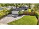 A house with a well-kept lawn, paved driveway, and a neatly attached garage, enhanced by tropical foliage at 1217 Kenwood Ave, Winter Park, FL 32789