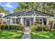 Charming single-story home featuring a landscaped yard, gray siding, and inviting front porch at 1217 Kenwood Ave, Winter Park, FL 32789