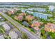 Aerial view showcasing multiple buildings, pools, and water features, with nearby lakes and roadways at 12527 Floridays Resort Dr # E104, Orlando, FL 32821