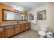 Bathroom featuring double sinks, a large mirror, tan walls and dark wood cabinets at 12527 Floridays Resort Dr # E104, Orlando, FL 32821