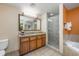 Bathroom featuring a large vanity and mirror, a walk-in shower, and a bathtub at 12527 Floridays Resort Dr # E104, Orlando, FL 32821