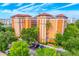 Beautiful resort condo building with lush trees and a colorful exterior paint job at 12527 Floridays Resort Dr # E104, Orlando, FL 32821