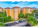 Striking exterior of a multi-story building with a parking lot and lush trees against a beautiful blue sky at 12527 Floridays Resort Dr # E104, Orlando, FL 32821