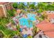 Aerial view of a resort-style pool with multiple lounge chairs and palm trees throughout the area at 12527 Floridays Resort Dr # E104, Orlando, FL 32821