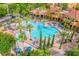 Resort-style swimming pool surrounded by palm trees, lounge chairs, and shade umbrellas at 12527 Floridays Resort Dr # E104, Orlando, FL 32821