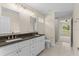 Bathroom featuring a double vanity, large mirrors, and access to a tiled shower and bedroom at 12756 Sw 80 St, Dunnellon, FL 34432