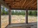 View of the outdoor space featuring concrete columns and wood-lined roof, with views of the surrounding landscape at 12756 Sw 80 St, Dunnellon, FL 34432