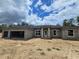 New construction showcasing a spacious front yard, an attached garage, and a modern architectural design at 12756 Sw 80 St, Dunnellon, FL 34432