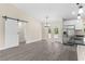Spacious living area with gray flooring, sliding barn door, stainless steel refrigerator, and white cabinets at 12756 Sw 80 St, Dunnellon, FL 34432