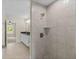 Walk-in shower is tiled and has a shower head, shelf, and brushed nickel hardware at 12756 Sw 80 St, Dunnellon, FL 34432