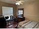 A cozy bedroom features wood floors, a ceiling fan, and a dresser with a mirror at 13000 Sandy Pine Ln, Clermont, FL 34711