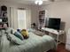 Bright bedroom with bookshelves, a desk, and a comfortable bed with decorative pillows at 13000 Sandy Pine Ln, Clermont, FL 34711