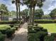 Gated community entrance with brick columns, lush landscaping, and secure access for residents at 13000 Sandy Pine Ln, Clermont, FL 34711