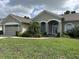 Charming single-story home featuring a well-manicured lawn and inviting front entrance with classic architectural details at 13000 Sandy Pine Ln, Clermont, FL 34711