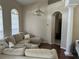 Inviting living room features a plush sectional sofa, elegant chandelier, and arched doorway at 13000 Sandy Pine Ln, Clermont, FL 34711