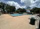 Community swimming pool surrounded by lounge chairs, lush landscaping, and clear blue skies at 13000 Sandy Pine Ln, Clermont, FL 34711