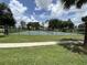 Community tennis court surrounded by lush greenery, perfect for sports enthusiasts at 13000 Sandy Pine Ln, Clermont, FL 34711