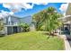 Expansive backyard featuring lush green grass, tropical landscaping, and an outdoor storage shed at 13691 Crystal River Dr, Orlando, FL 32828